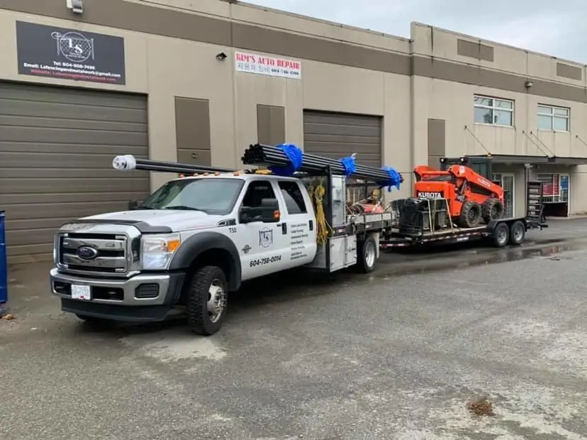 LS Fencing crew truck with equipment transport trailer.